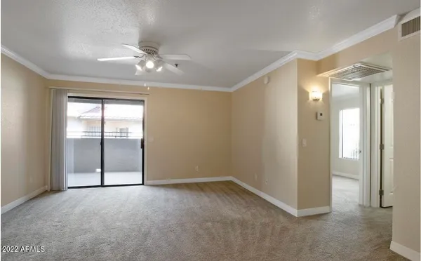 an empty room with fan and windows