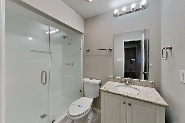 a bathroom with a granite countertop sink toilet and shower