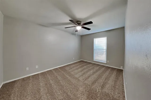 a view of an empty room and a ceiling fan chandelier fan