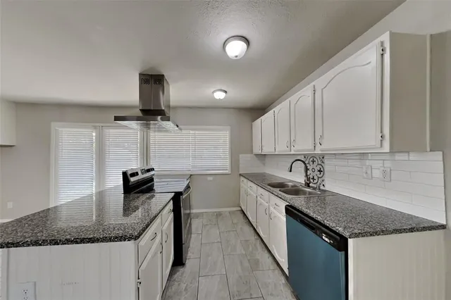 a kitchen with granite countertop a sink and a stove