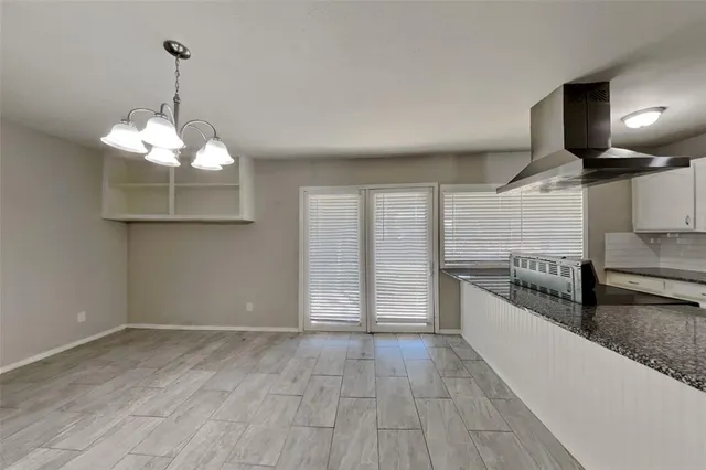 a kitchen with stainless steel appliances granite countertop a stove a sink and a wooden floors