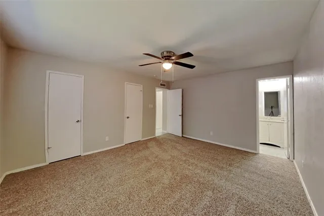 a view of an empty room with a ceiling fan