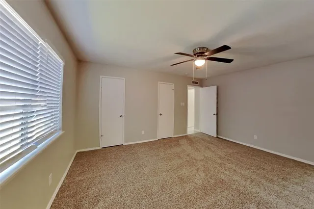 a view of an empty room with a ceiling fan