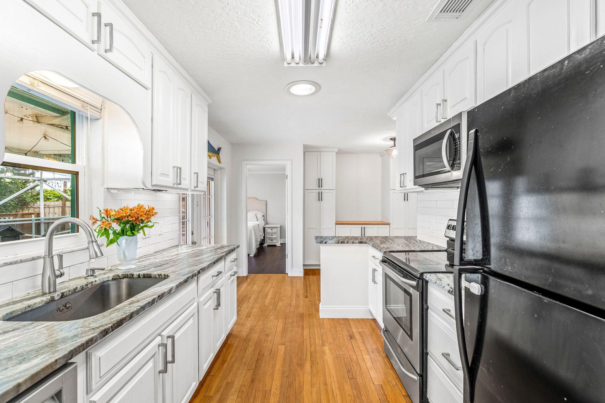 680 Mark Drive Melbourne, FL 32904 - Photo 7 of 36 a kitchen with stainless steel appliances granite countertop a sink a stove and a wooden floors