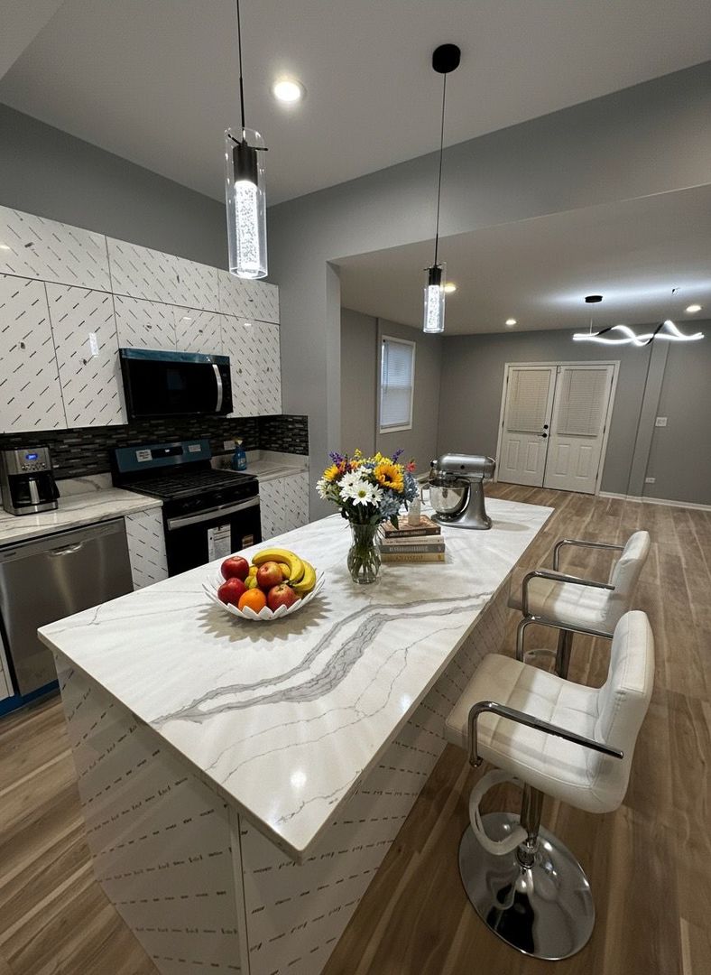 62 West 113th Street Chicago, IL 60628 - Photo 14 of 54 a kitchen with a sink a stove and chairs