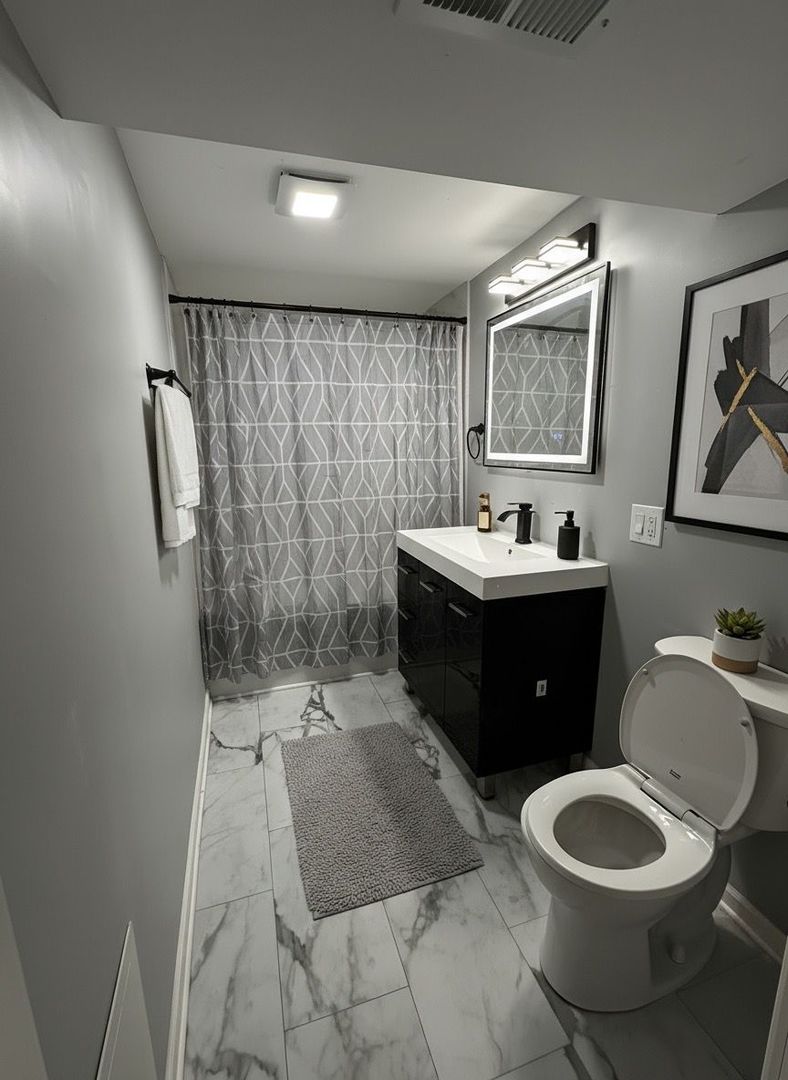 62 West 113th Street Chicago, IL 60628 - Photo 34 of 54 a bathroom with a sink toilet and mirror