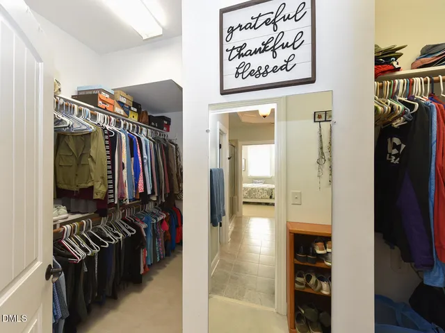 a view of walk in closet with clothes and shoes