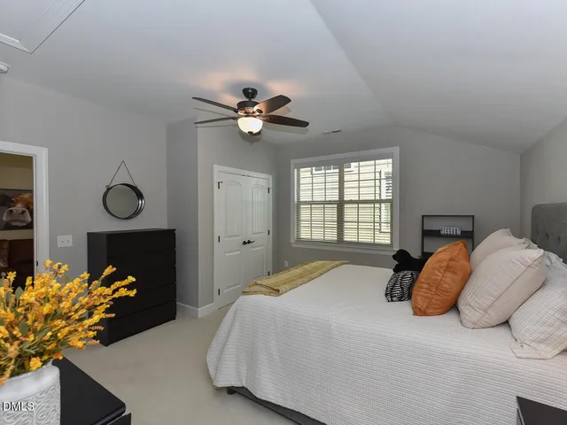 a bedroom with a bed mirror and window