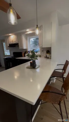 a kitchen with a sink a stove and chairs