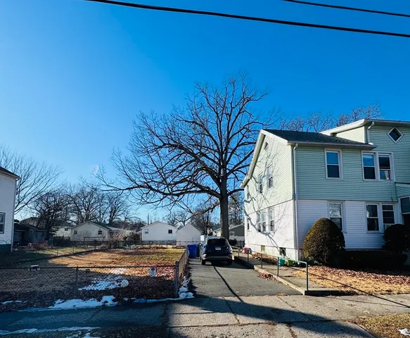a front view of a house with garden and trees