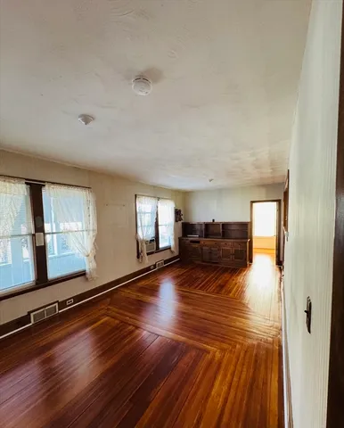 a living room with hard wood floors and a window