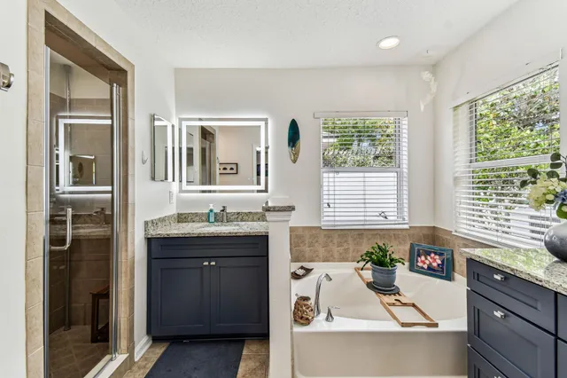 a bathroom with a granite countertop toilet sink and mirror
