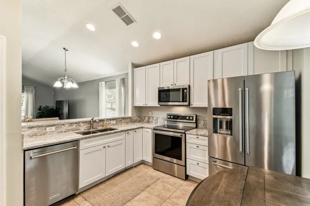 a kitchen with stainless steel appliances a stove refrigerator sink and microwave