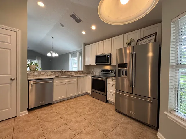 a kitchen with a refrigerator a sink and cabinets