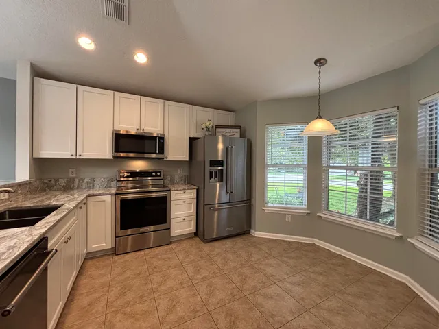 a kitchen with refrigerator a stove a sink and a microwave