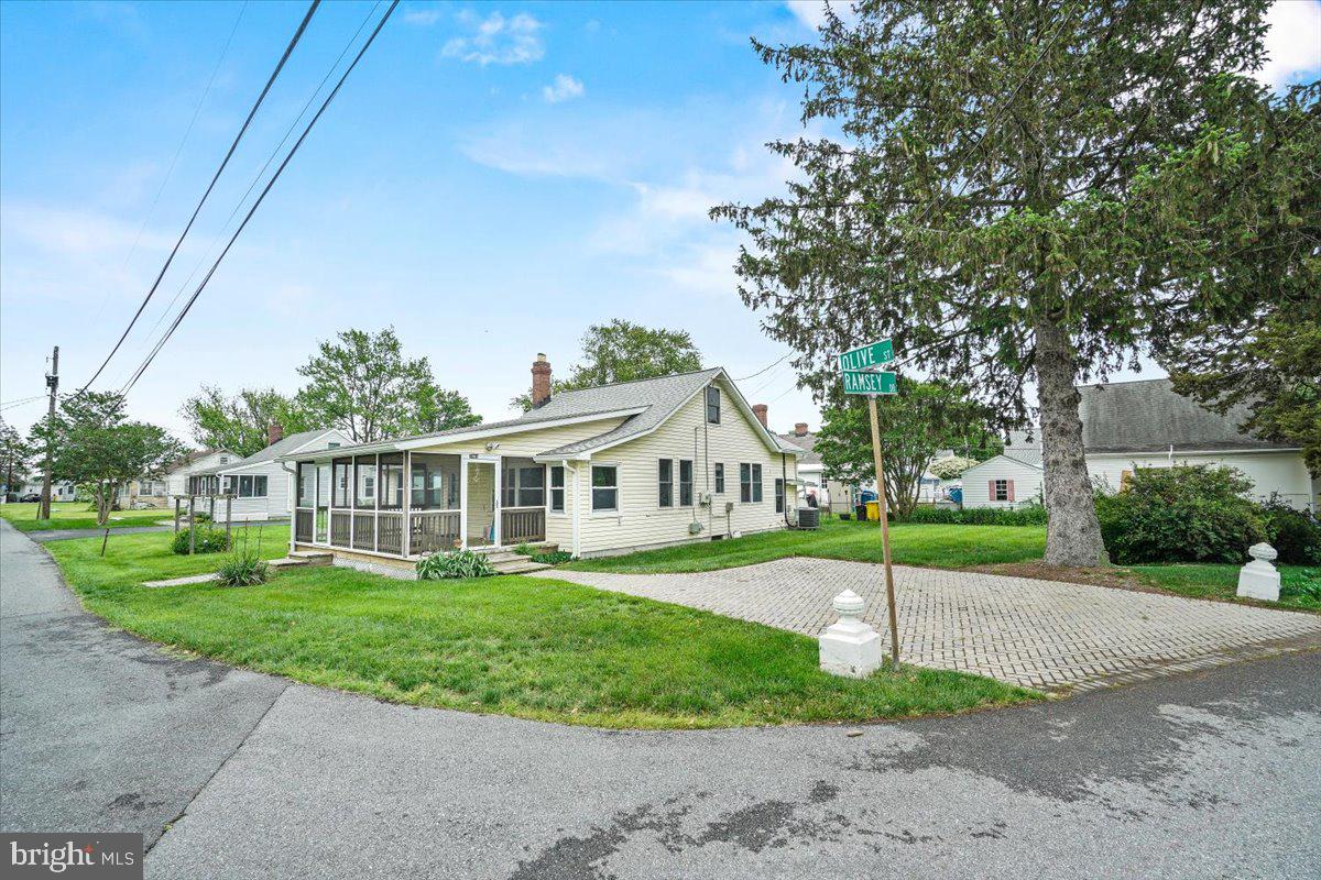 a front view of a house with a yard and trees