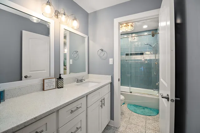 a bathroom with a granite countertop sink mirror and shower
