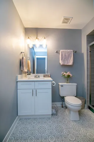 a bathroom with a toilet sink and mirror