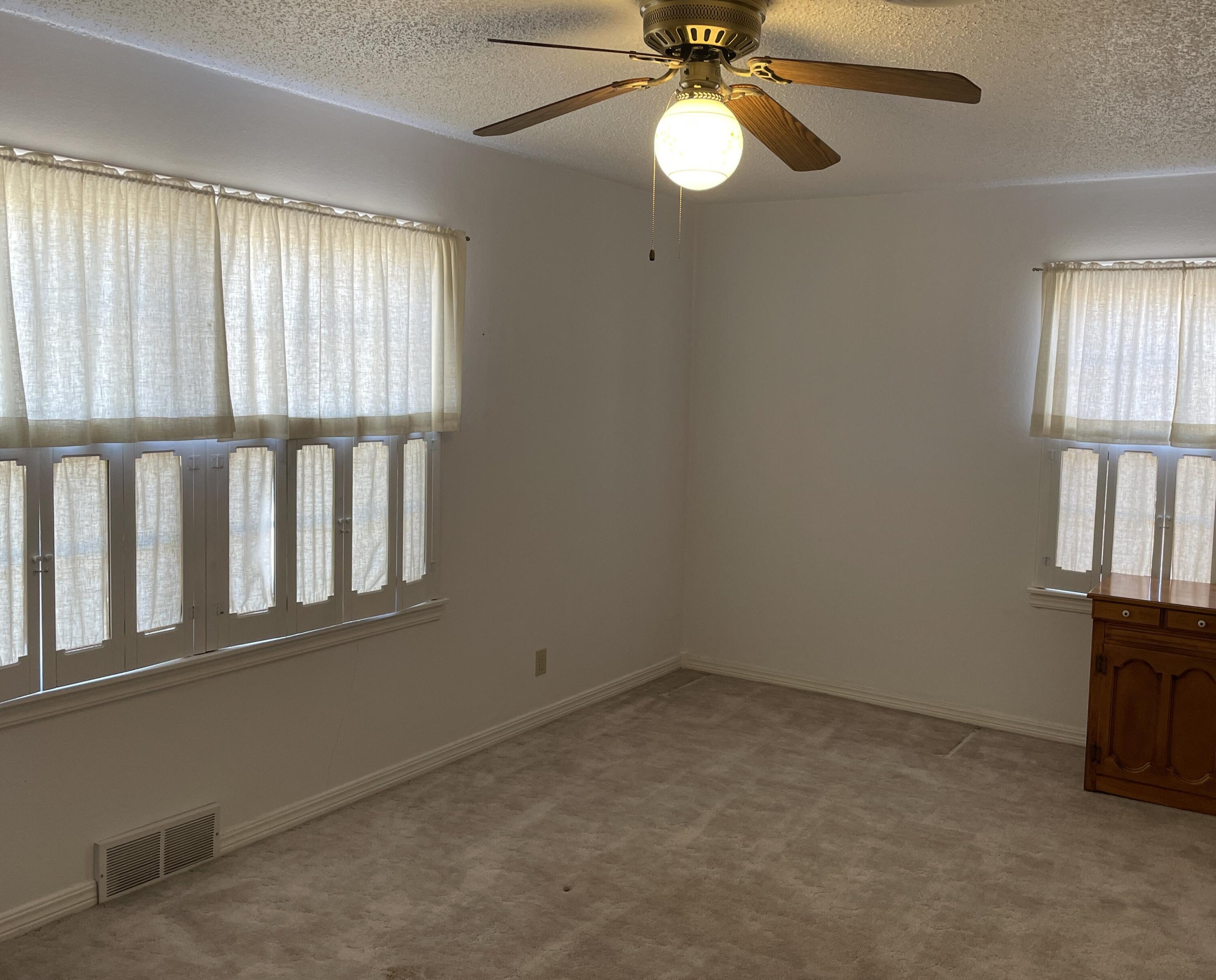 817 North 16th Street Lamesa, TX 79331 - Photo 8 of 12 an empty room with windows and fan