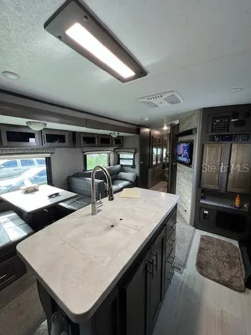 a kitchen with stainless steel appliances kitchen island granite countertop a table chairs in it and wooden floors