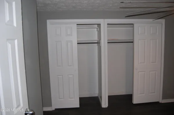 a view of a hallway with wooden floor and entryway