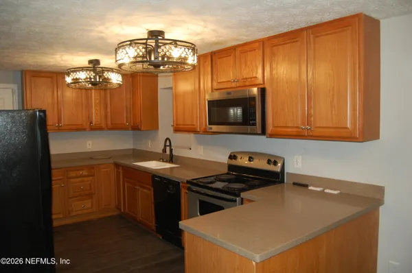 a kitchen with stainless steel appliances a stove a microwave a sink and cabinets