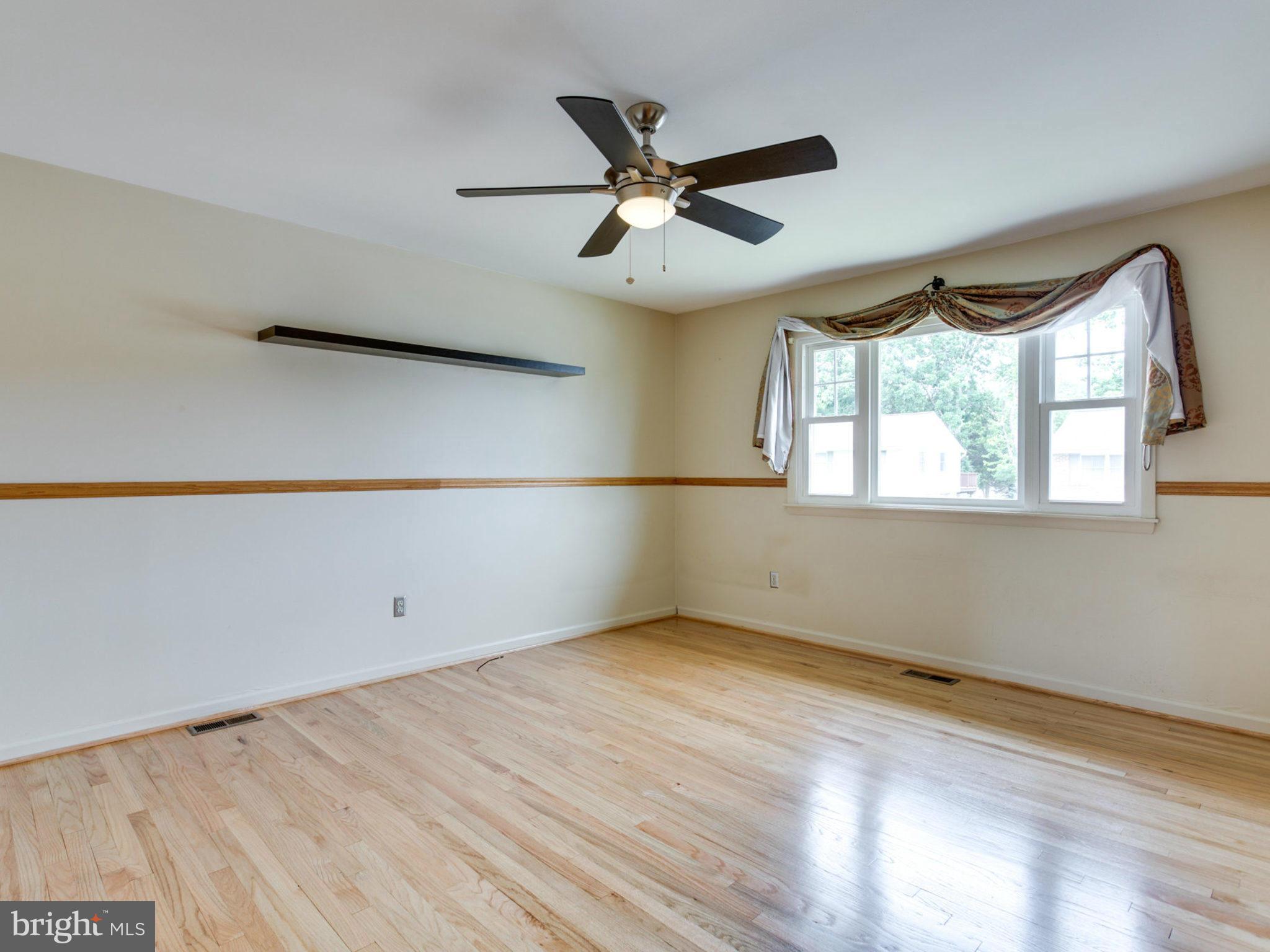 415 Rockway Road Catonsville, MD 21228 - Photo 3 of 30 an empty room with wooden floor fan and windows