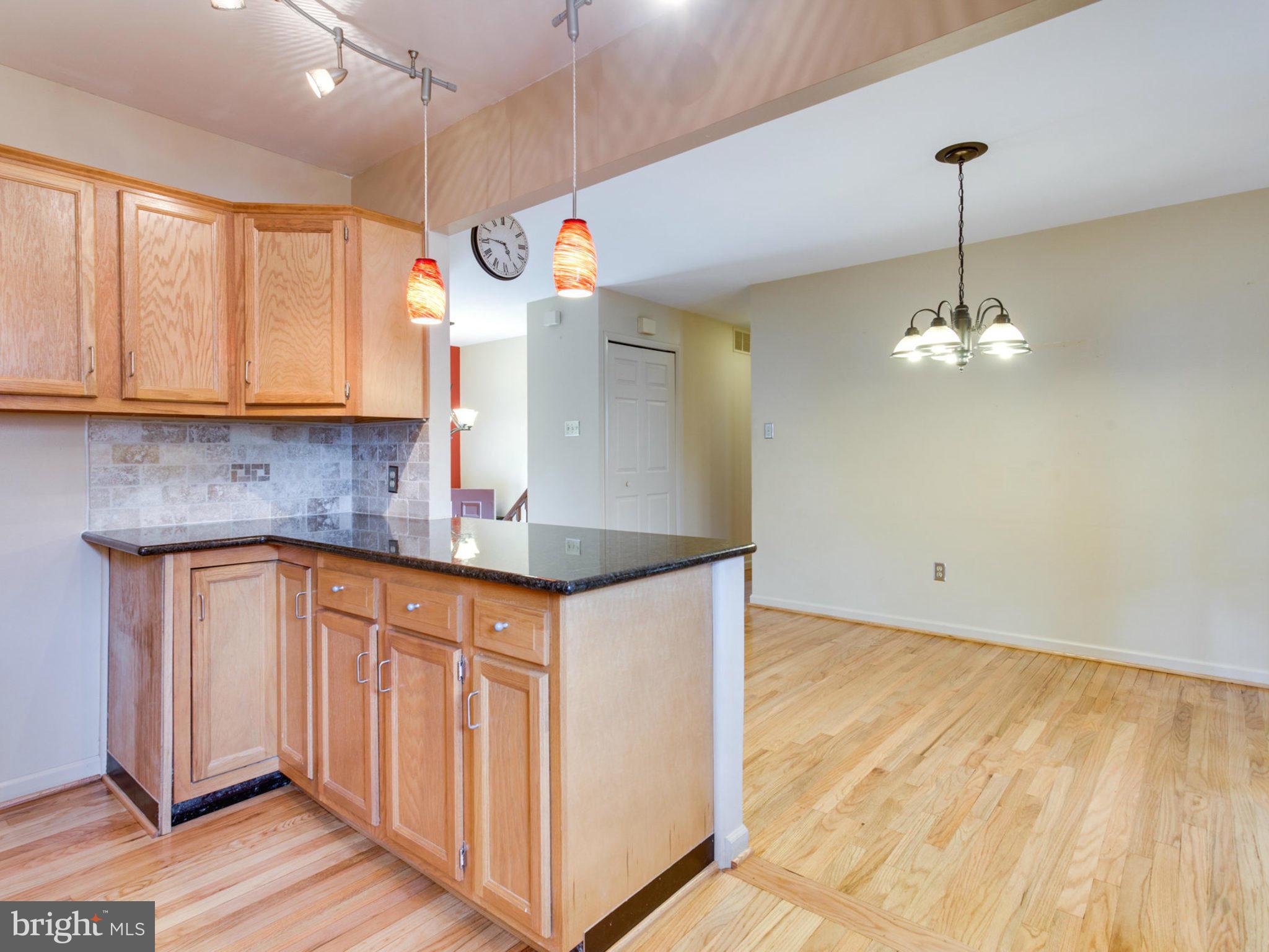 415 Rockway Road Catonsville, MD 21228 - Photo 9 of 30 a kitchen with stainless steel appliances granite countertop a sink a refrigerator cabinets and wooden floor