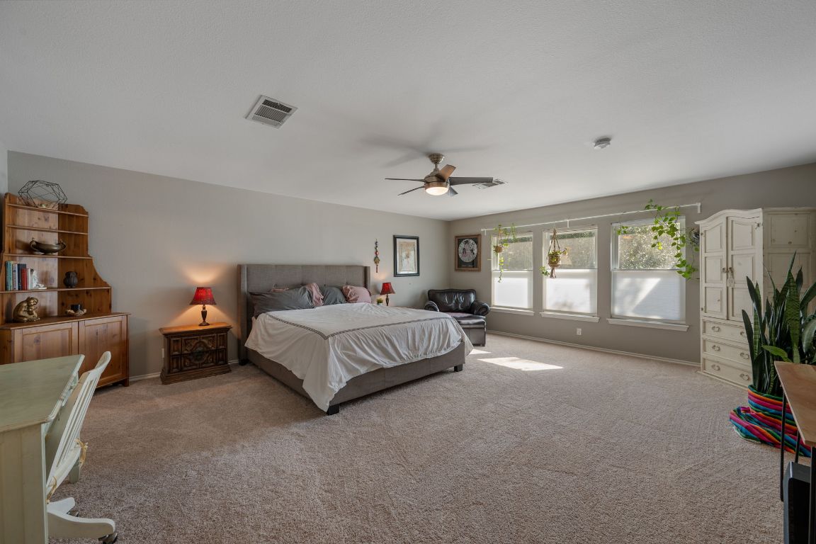 1607 Azalea Drive Cedar Park, TX 78613 - Photo 16 of 40 a spacious bedroom with a bed and a couch