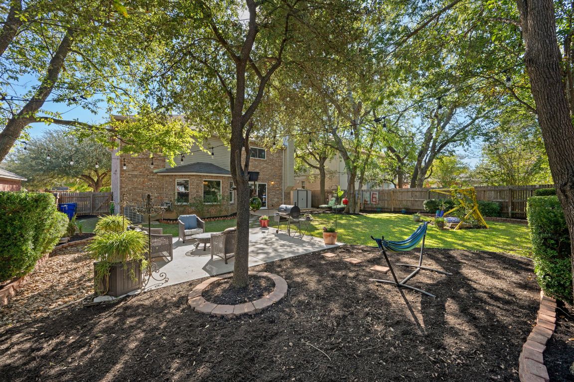 1607 Azalea Drive Cedar Park, TX 78613 - Photo 27 of 40 a view of a backyard with table and chairs potted plants and large tree