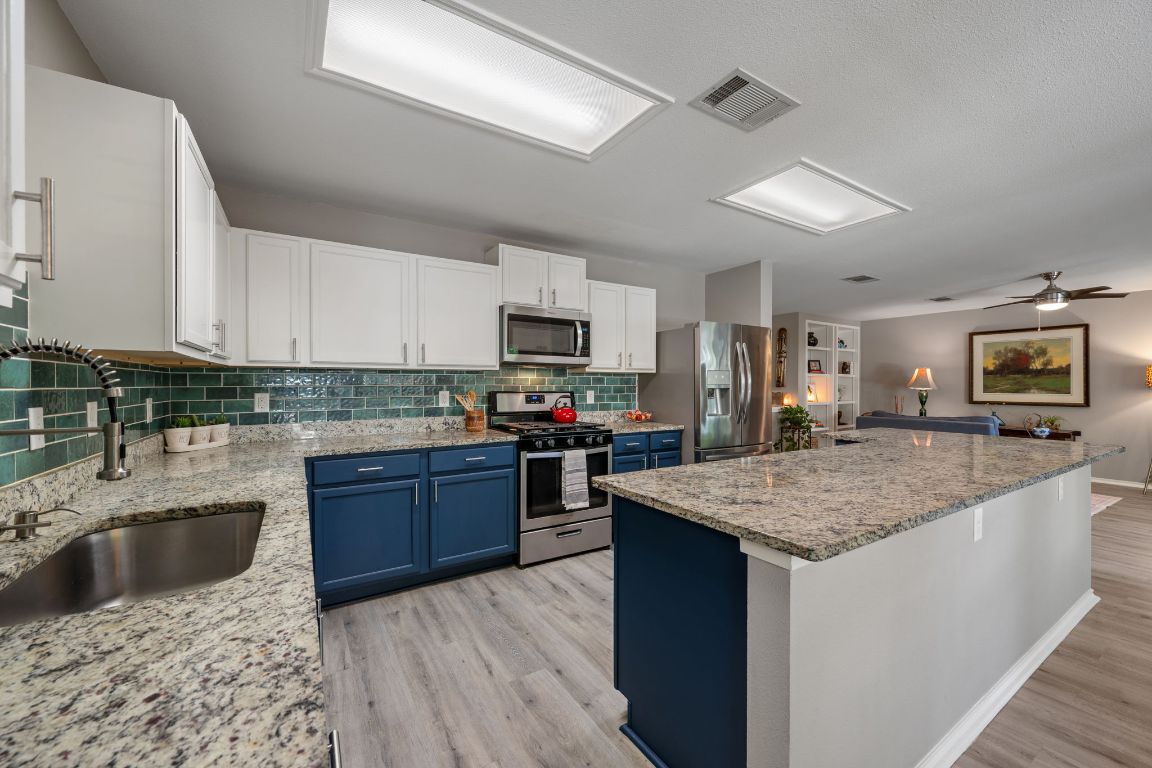 1607 Azalea Drive Cedar Park, TX 78613 - Photo 9 of 40 a kitchen with a stove a sink and a refrigerator
