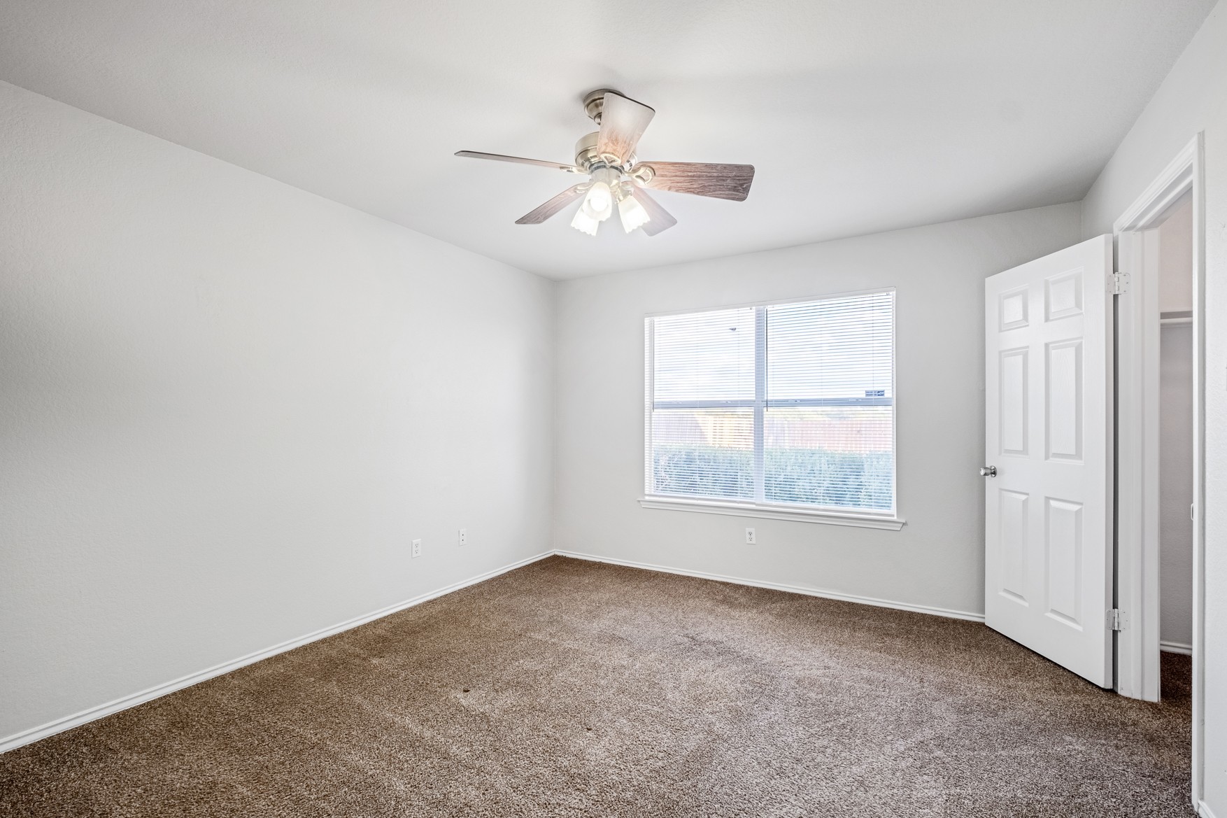 3709 Crownover Street Austin, TX 78725 - Photo 11 of 26 The room features neutral-toned carpet, white walls, and a ceiling fan with integrated lighting