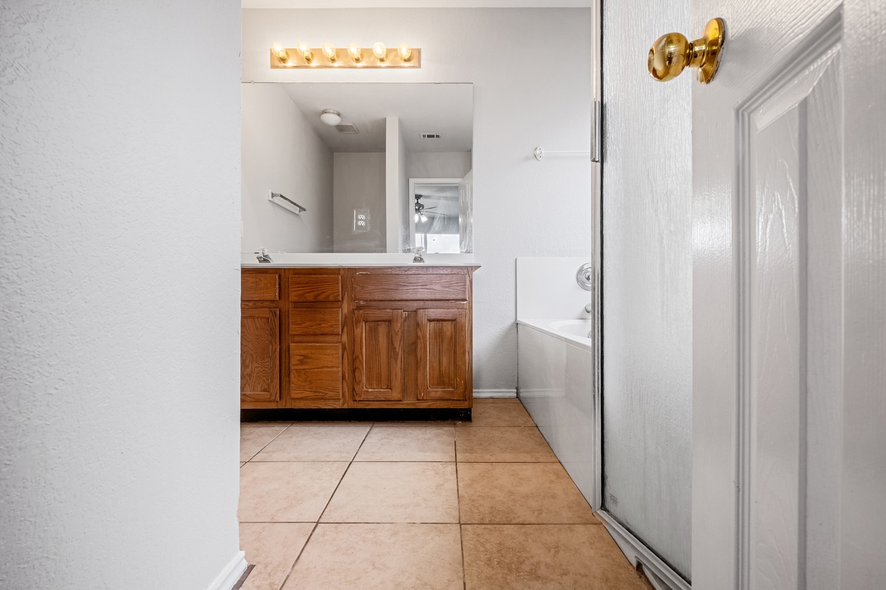 3709 Crownover Street Austin, TX 78725 - Photo 13 of 26 The bathroom features a double vanity with wood cabinetry, a large mirror, and tiled flooring