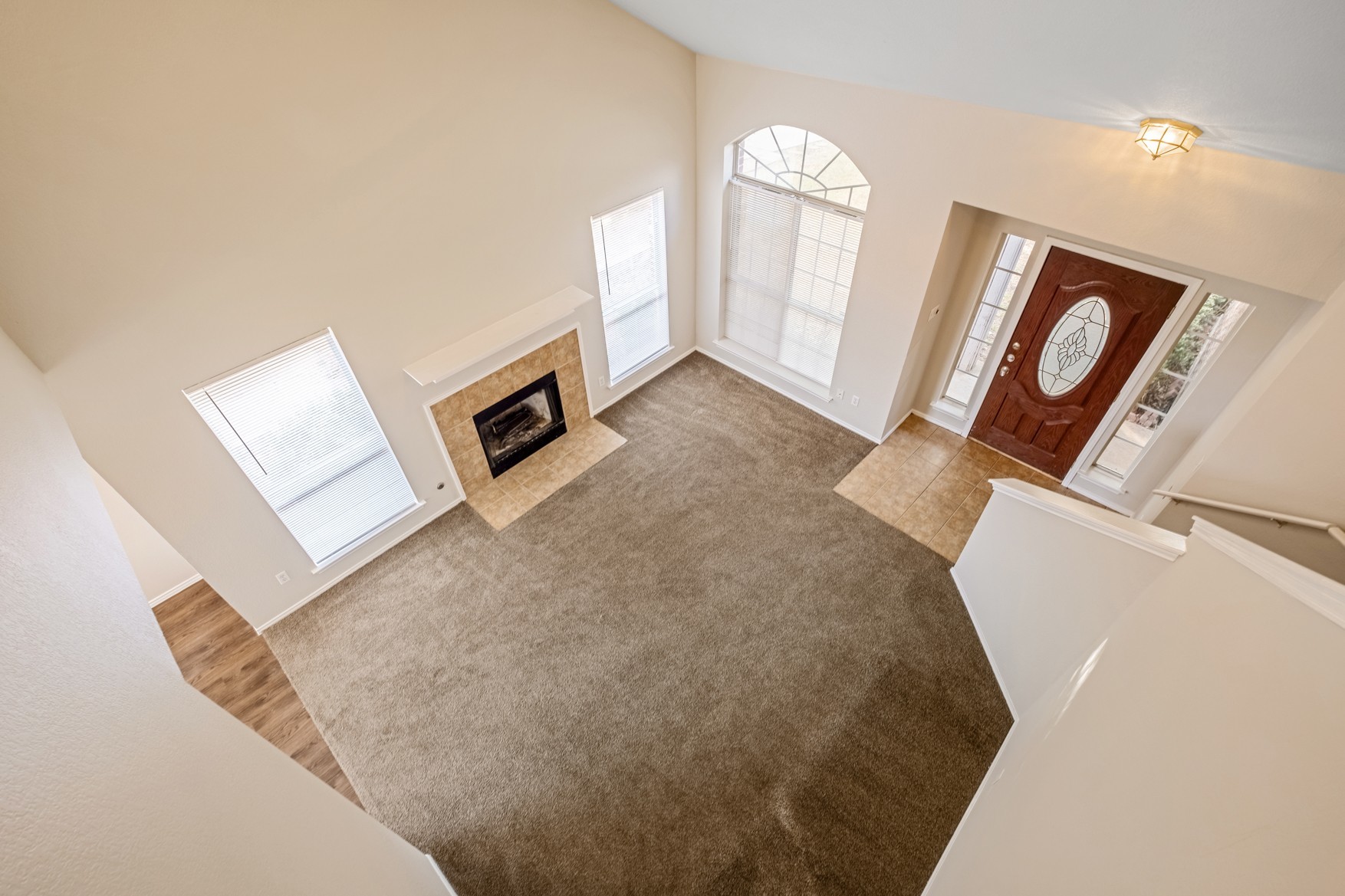 3709 Crownover Street Austin, TX 78725 - Photo 18 of 26 The living area features a carpeted floor, a fireplace with a tiled surround and mantel, and high ceilings