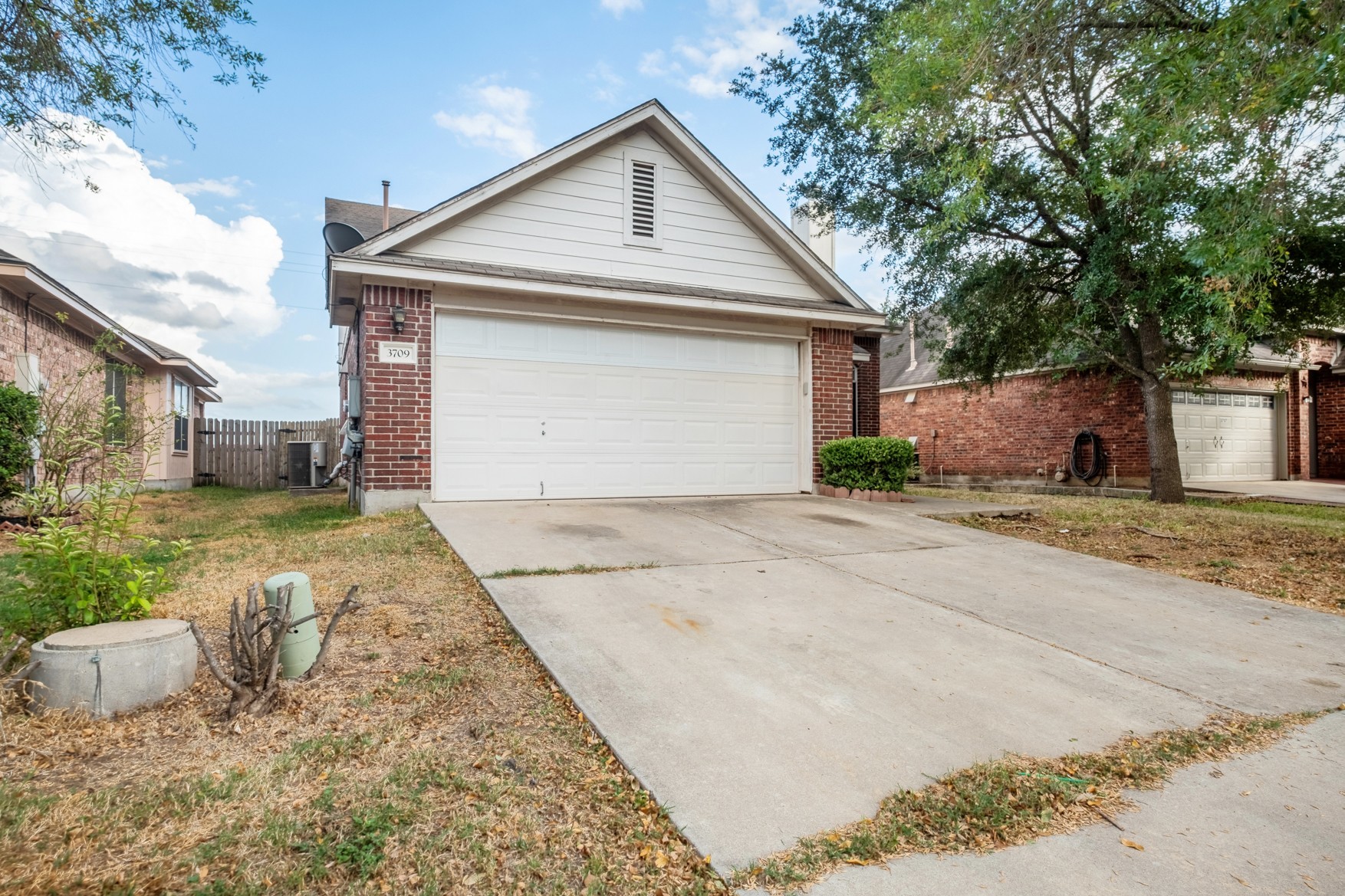 3709 Crownover Street Austin, TX 78725 - Photo 2 of 26 This property features a brick exterior with white siding, an attached garage, and a concrete driveway