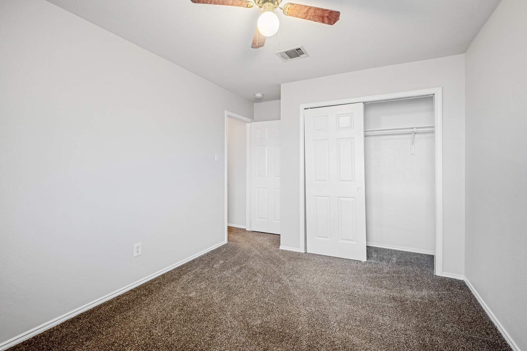 3709 Crownover Street Austin, TX 78725 - Photo 22 of 26 This room features soft gray carpet, white walls, a ceiling fan with integrated lighting, and a closet with bi-fold doors