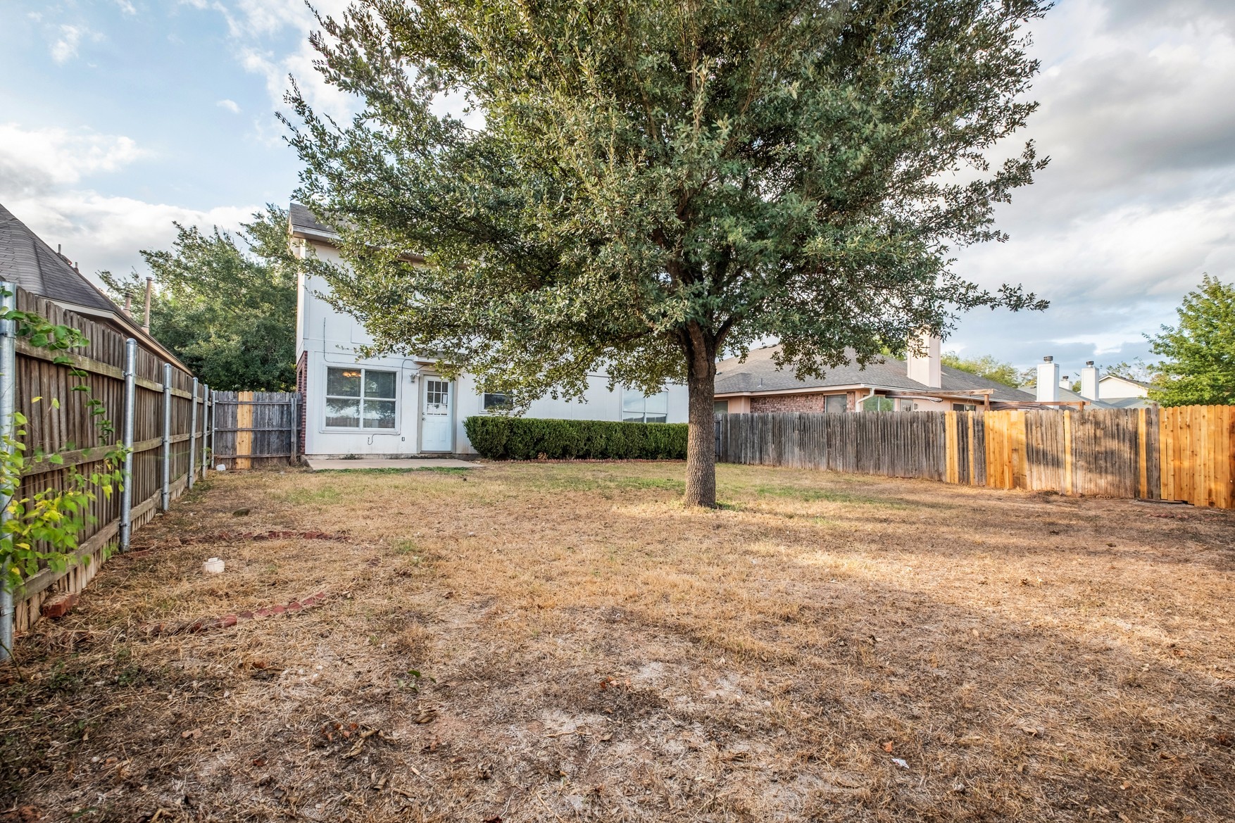 3709 Crownover Street Austin, TX 78725 - Photo 24 of 26 The property features a fenced yard, a patio area, and a mature tree