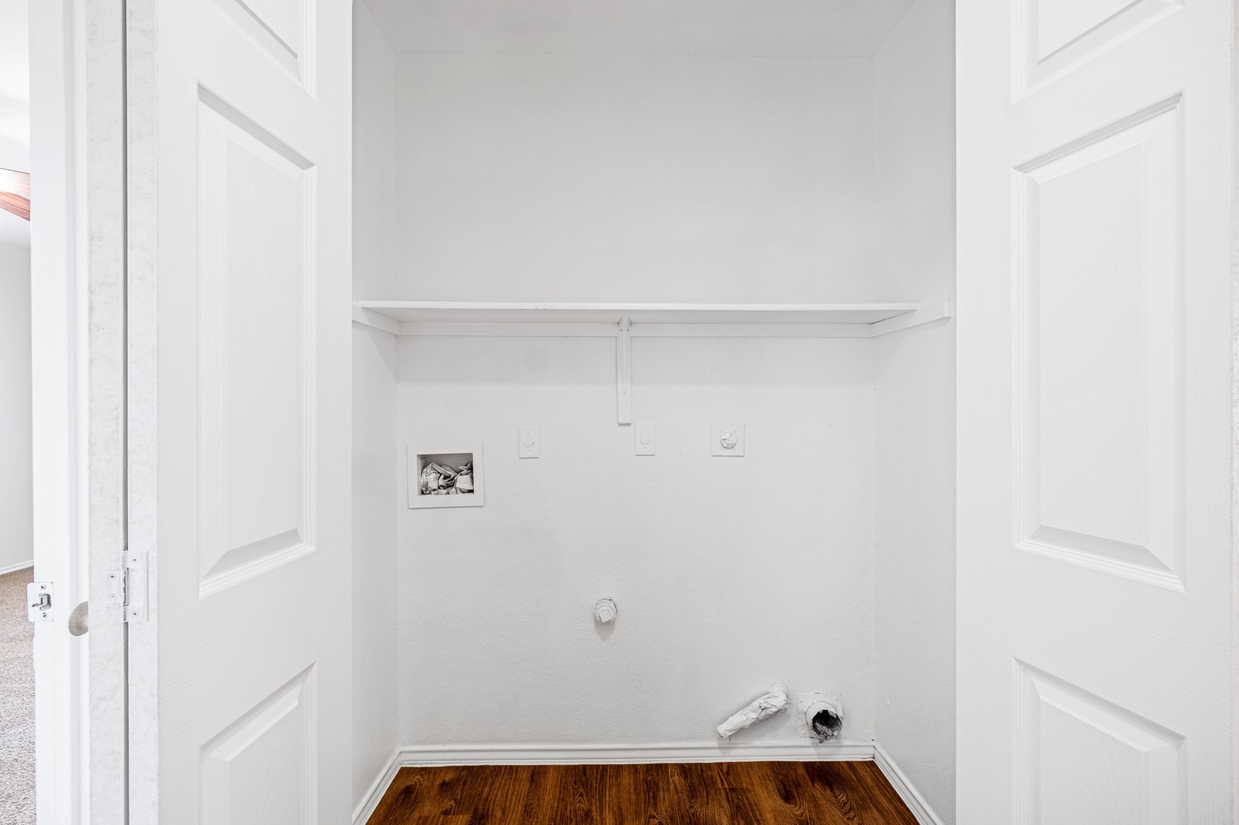 3709 Crownover Street Austin, TX 78725 - Photo 10 of 26 Utility closet featuring a white shelf, white walls, and wood-look flooring