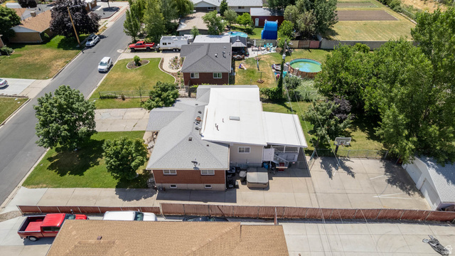 1489 North 400 West Bountiful, UT 84010 - Photo 47 of 47 Brick and siding residence with a covered patio, paved driveway, mature trees, and a gravel parking area
