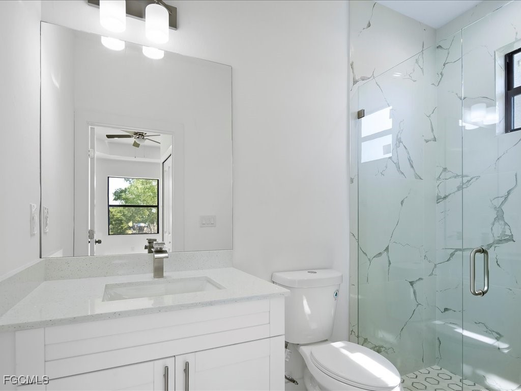 5210 28th Street Southwest Lehigh Acres, FL 33973 - Photo 9 of 12 a bathroom with a sink vanity granite toilet and a mirror