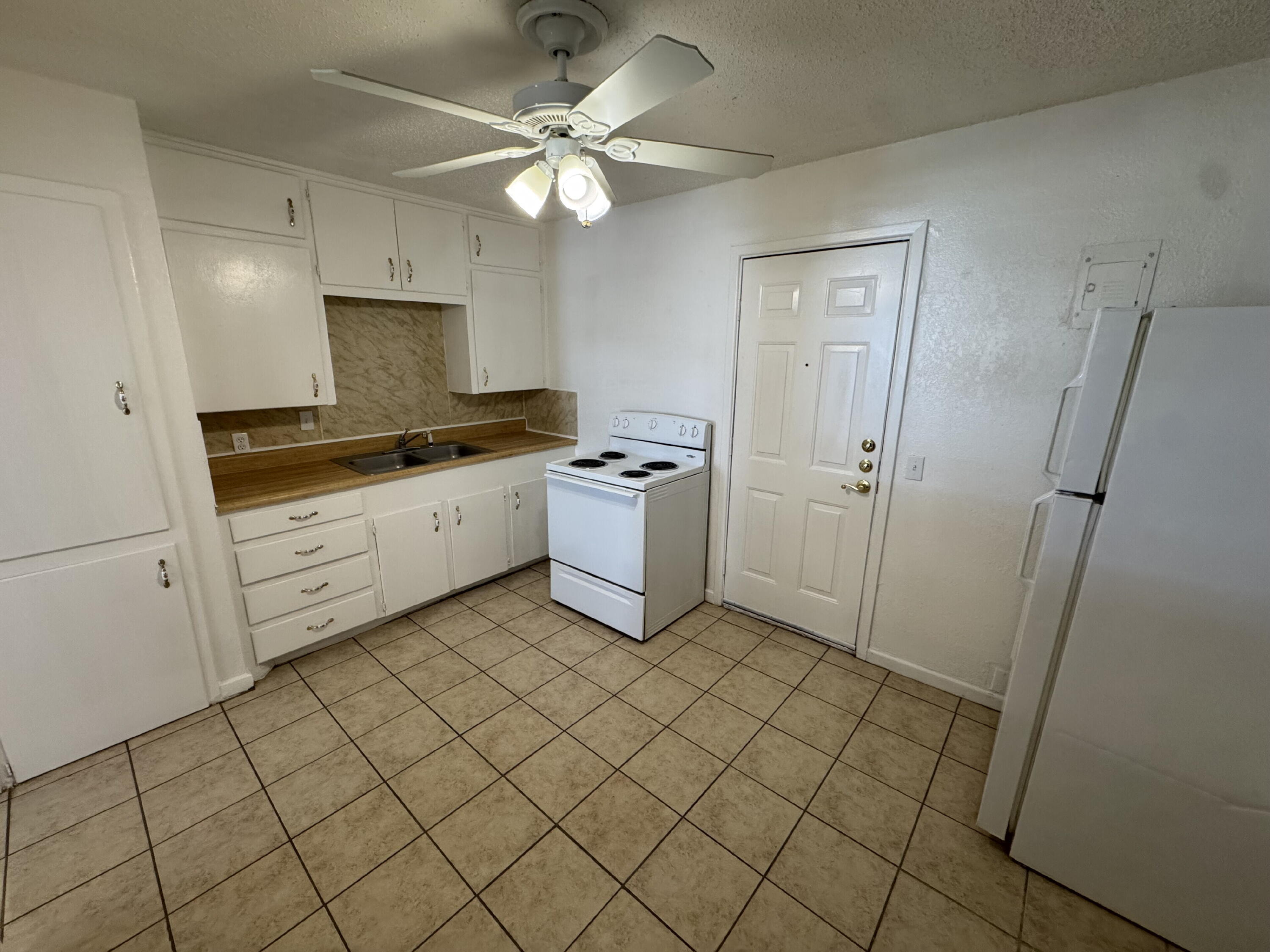 2208 35th Street, Unit B Lubbock, TX 79412 - Photo 4 of 9 a kitchen with stainless steel appliances a sink and a refrigerator
