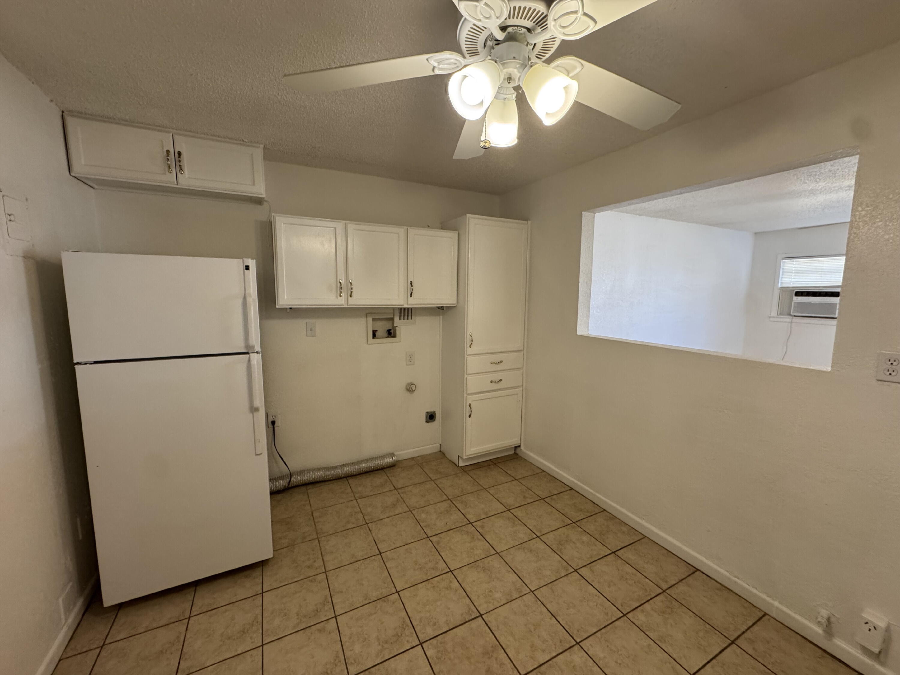 2208 35th Street, Unit B Lubbock, TX 79412 - Photo 5 of 9 a view of a kitchen with a refrigerator and a microwave