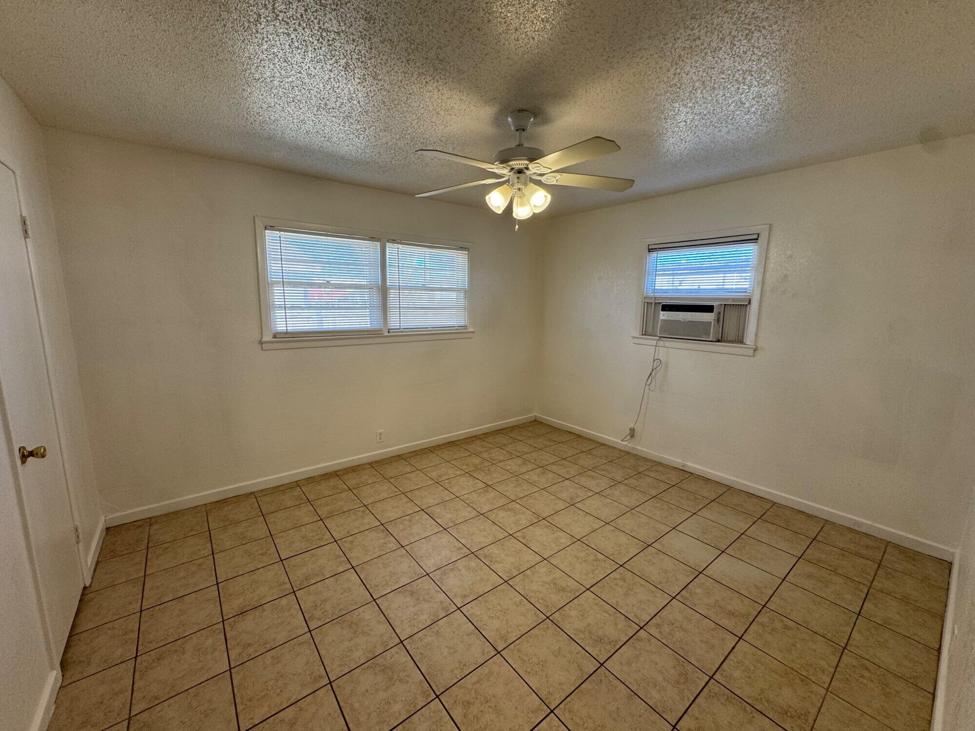 2208 35th Street, Unit B Lubbock, TX 79412 - Photo 7 of 9 an empty room with windows and fan