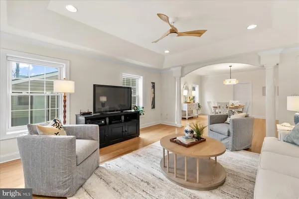 a living room with furniture kitchen view and a large window