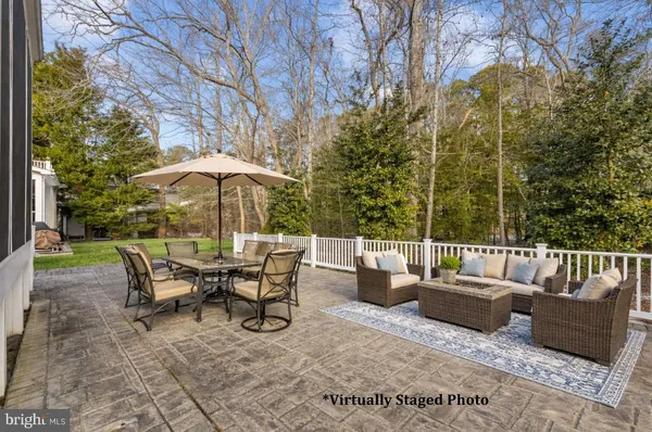 a view of a patio with couches and a table and chairs under an umbrella