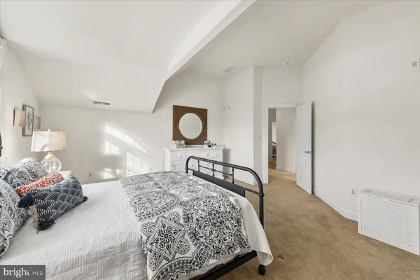 a bedroom with a bed and a large mirror