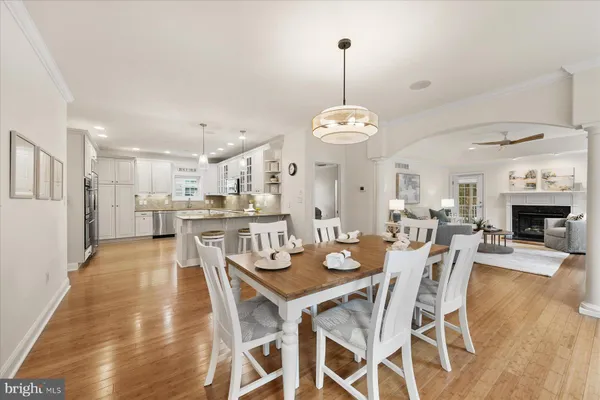 a view of a dining room and livingroom with furniture wooden floor a chandelier