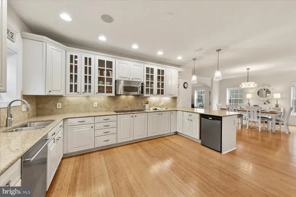 a large kitchen with kitchen island a sink stainless steel appliances and cabinets