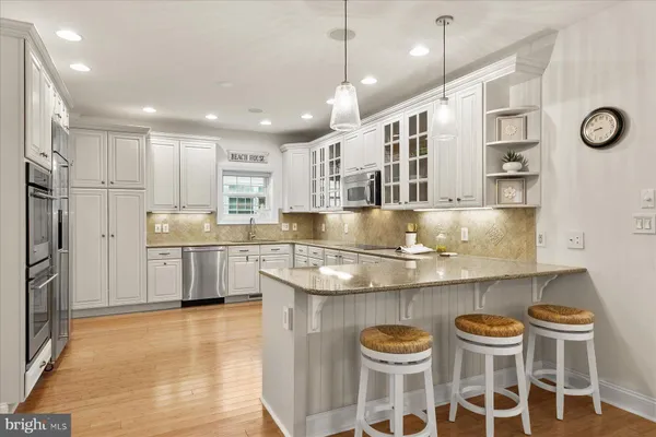 a kitchen with stainless steel appliances granite countertop a sink and a refrigerator