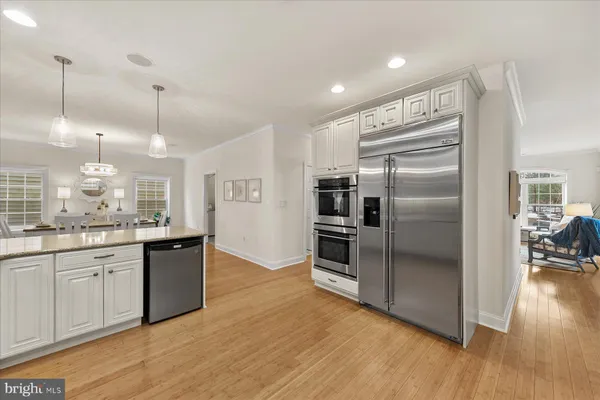 a kitchen with stainless steel appliances granite countertop a refrigerator a sink and a stove